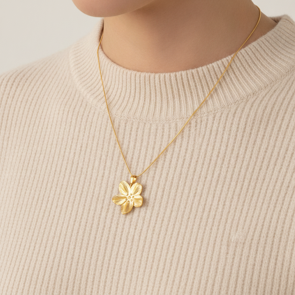 Blomst pendant i gullkjede rundt en hals. 